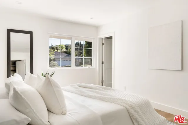 a large bed sitting in a bedroom next to a window