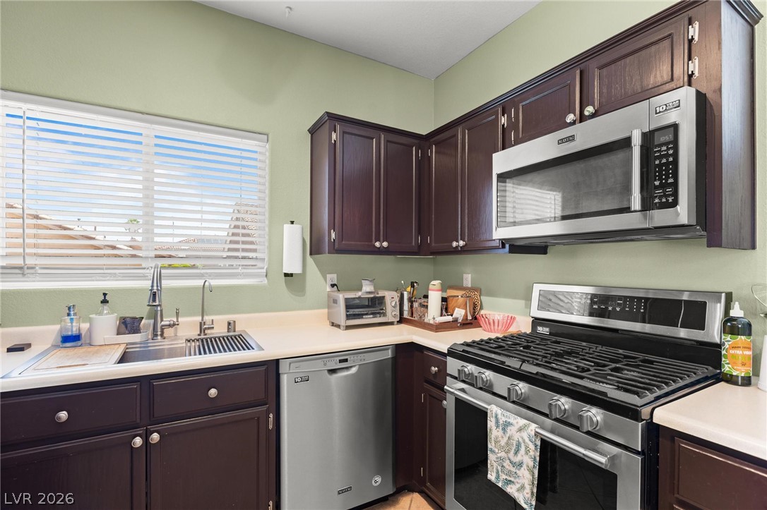 3238 Mystic Ridge Court Las Vegas, NV 89129 - Photo 6 of 31 Prepare meals in a kitchen featuring sleek stainless steel appliances and ample counter space.