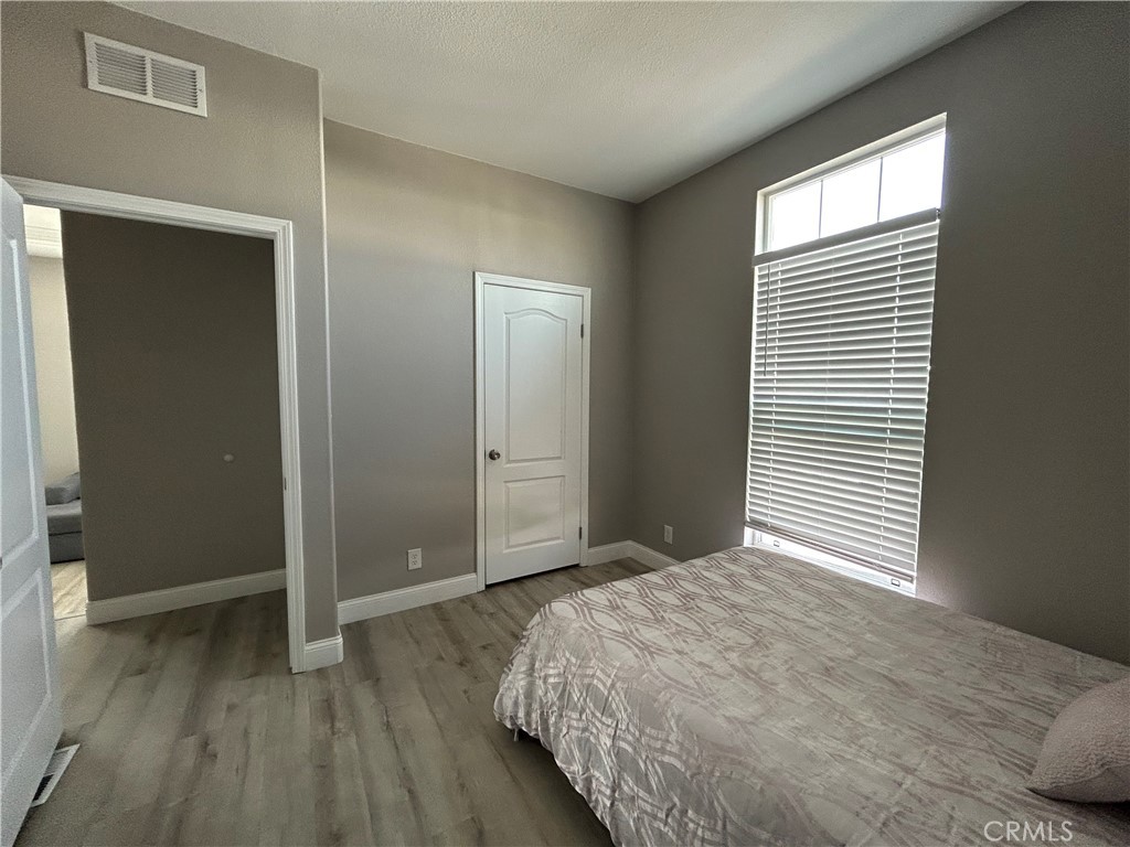 10550 Western Avenue, Unit 32 Stanton, CA 90680 - Photo 22 of 31 a bedroom with a bed and wooden floor
