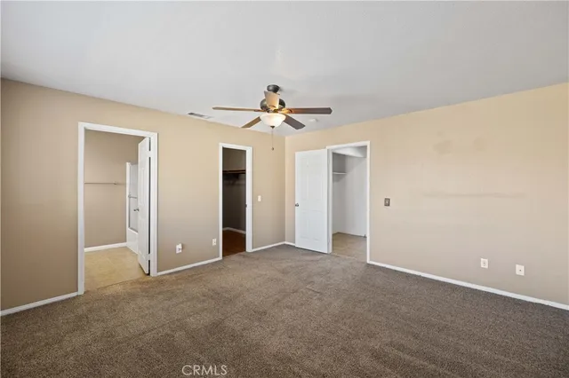 a view of an empty room with a ceiling fan