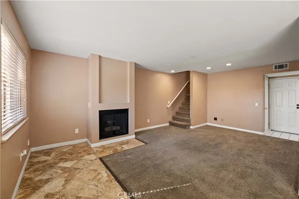 an empty room with a fireplace and window