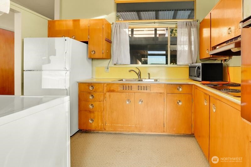 18822 Olympic View Drive Edmonds, WA 98020 - Photo 6 of 20 a utility room with a refrigerator and a stove