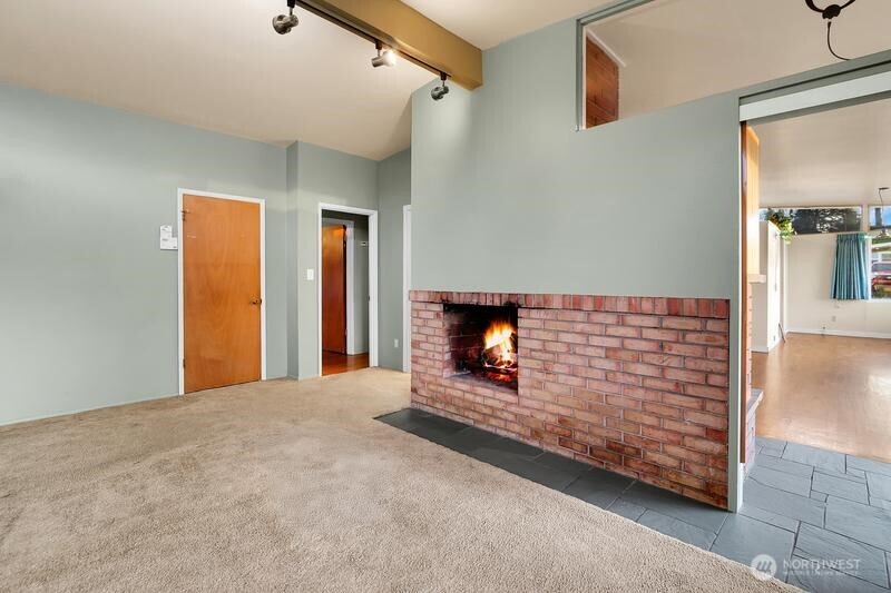 18822 Olympic View Drive Edmonds, WA 98020 - Photo 8 of 20 a view of an empty room with wooden floor and a fireplace