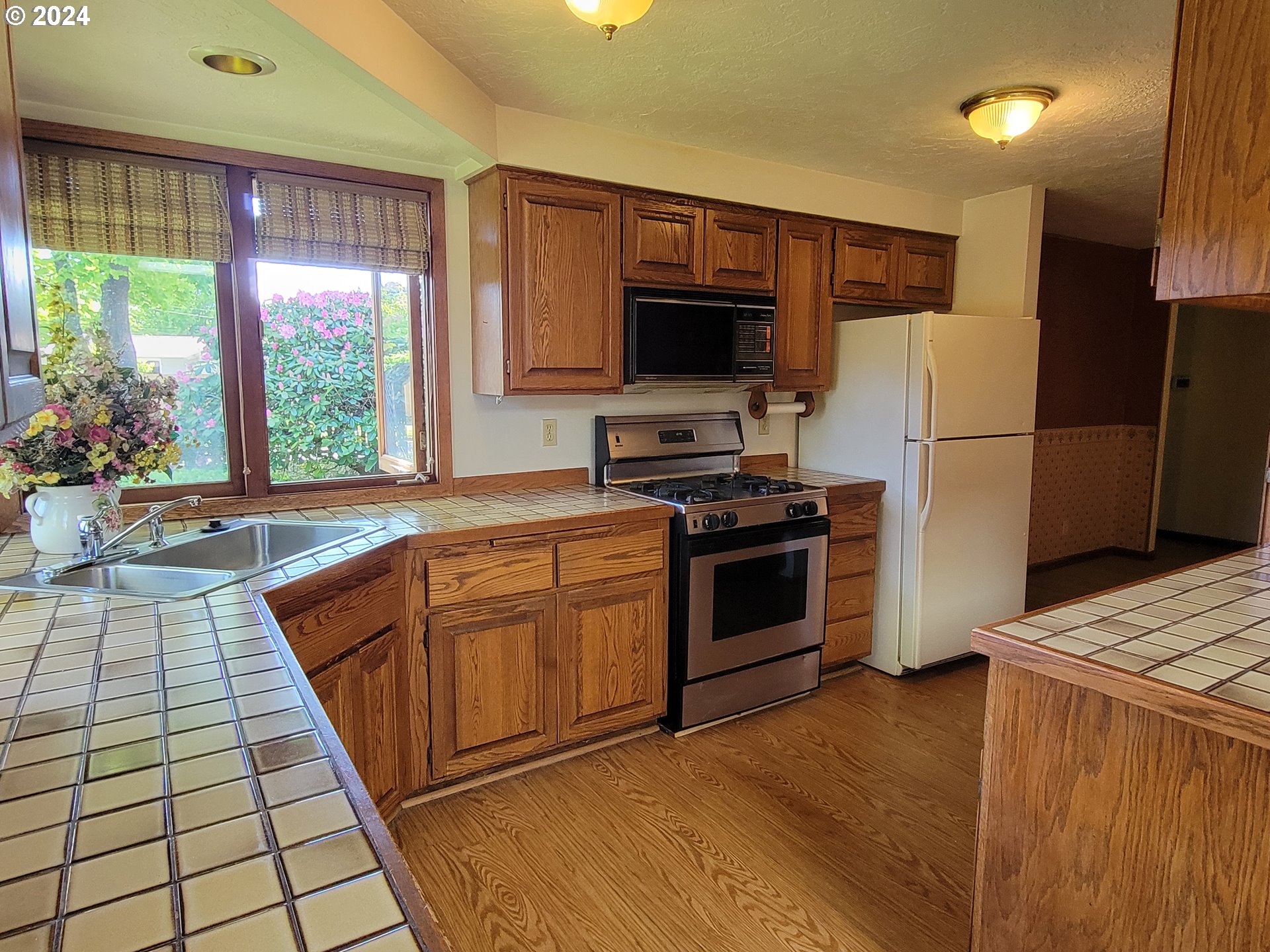 2565 Newcastle Street Eugene, OR 97404 - Photo 19 of 38 a kitchen with stainless steel appliances kitchen island granite countertop a stove a sink dishwasher and a refrigerator