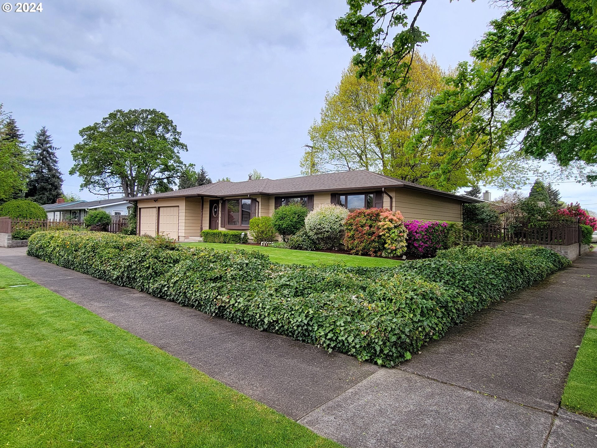 2565 Newcastle Street Eugene, OR 97404 - Photo 3 of 38 a front view of a house with a lot of flower garden