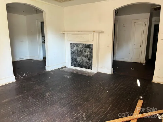 an empty room with wooden floor and a fireplace