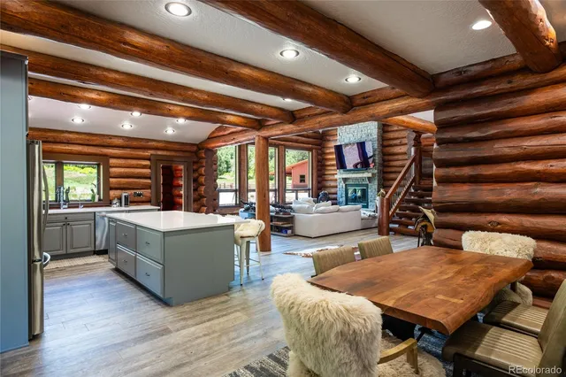 a kitchen with stainless steel appliances granite countertop a refrigerator a sink dishwasher a stove and a refrigerator with wooden floor