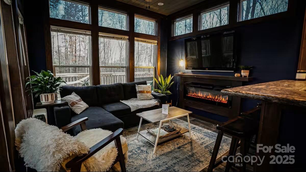 221 Summerfield Lane Rutherfordton, NC 28139 - Photo 7 of 37 a living room with furniture a flat screen tv and a floor to ceiling window