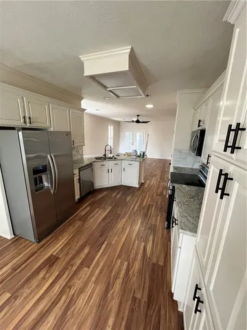 a open kitchen with cabinets a sink and wooden floor