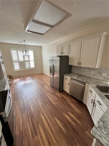 a kitchen with a sink a refrigerator and cabinets