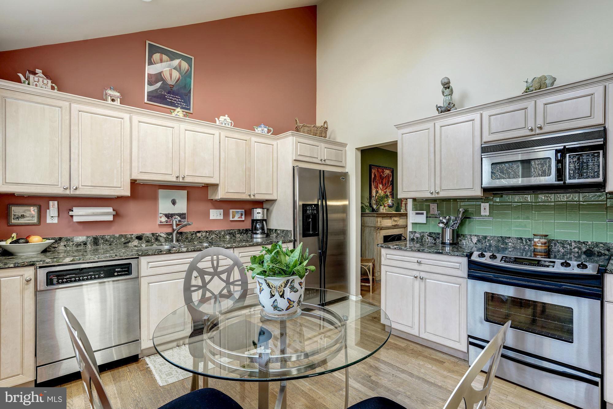 1416 Green Run Lane Reston, VA 20190 - Photo 7 of 29 a kitchen with stainless steel appliances kitchen island granite countertop a stove a sink and a microwave