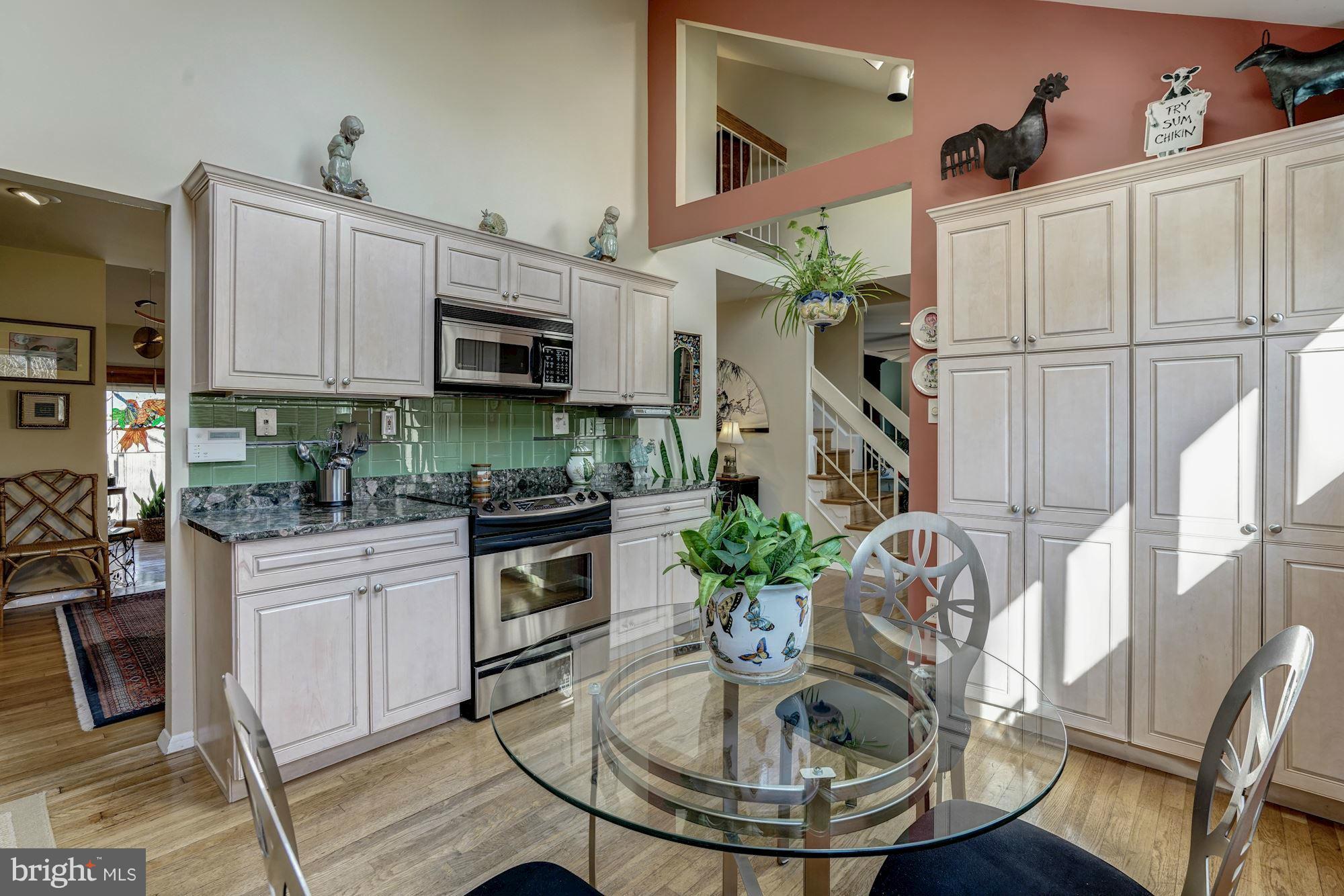 1416 Green Run Lane Reston, VA 20190 - Photo 8 of 29 a kitchen with stainless steel appliances granite countertop a sink a stove a dining table and chairs