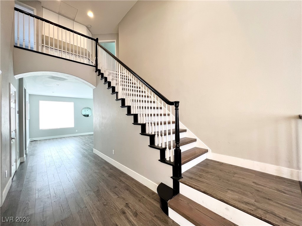 2218 Armacost Drive Henderson, NV 89074 - Photo 19 of 31 Stairway with arched walkways, a towering ceiling, and wood finished floors
