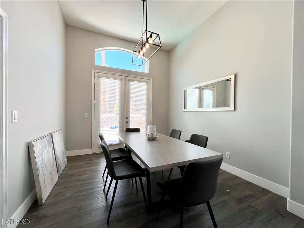 2218 Armacost Drive Henderson, NV 89074 - Photo 7 of 31 Dining space with french doors, dark wood finished floors, a chandelier, and a towering ceiling