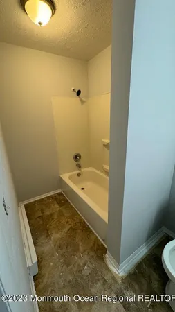 a bathroom with a tub and toilet