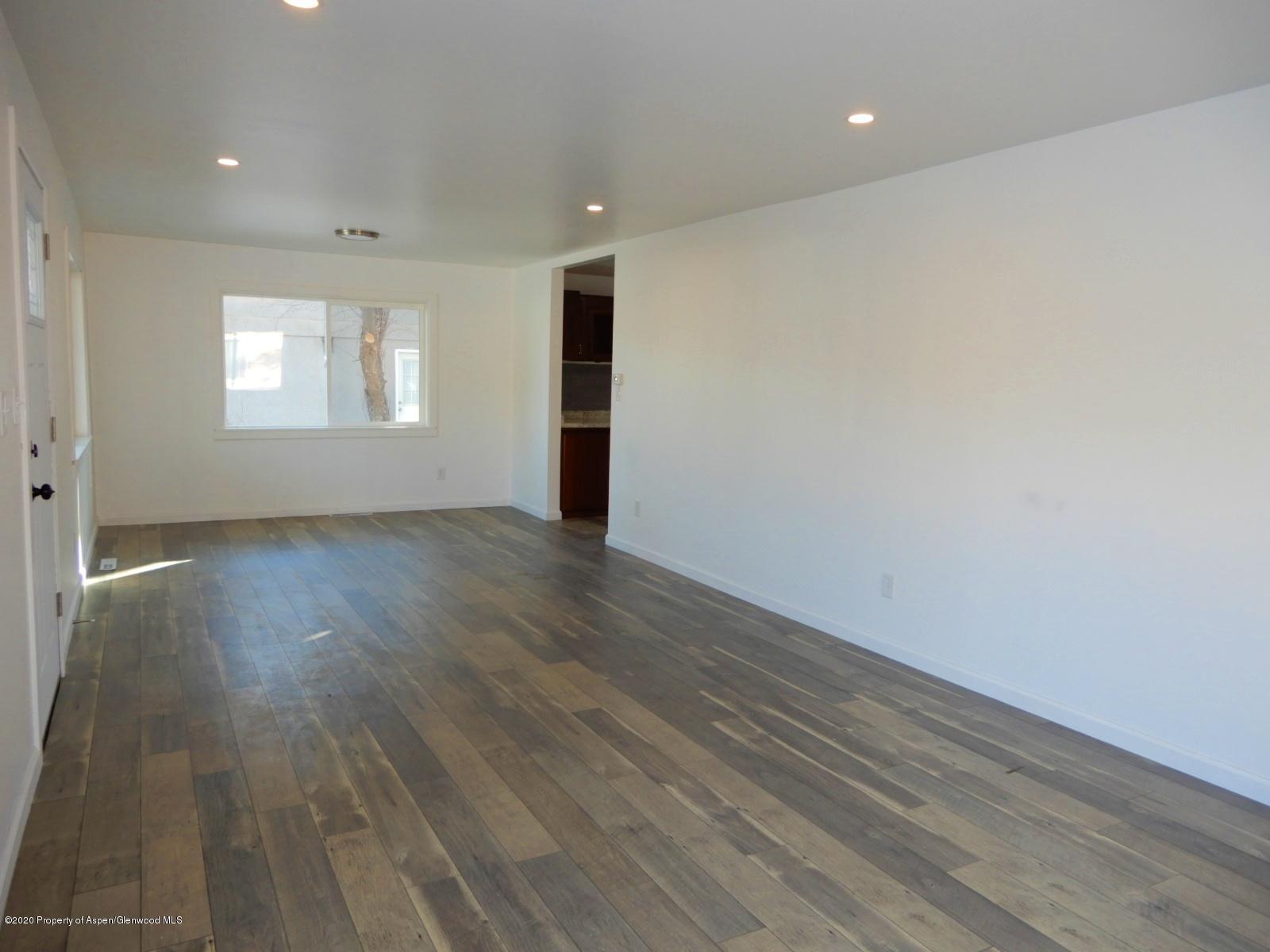 119 June Avenue Rifle, CO 81650 - Photo 11 of 24 an empty room with wooden floor and windows