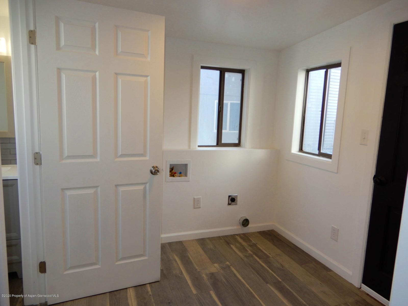 119 June Avenue Rifle, CO 81650 - Photo 12 of 24 an empty room with wooden floor and windows