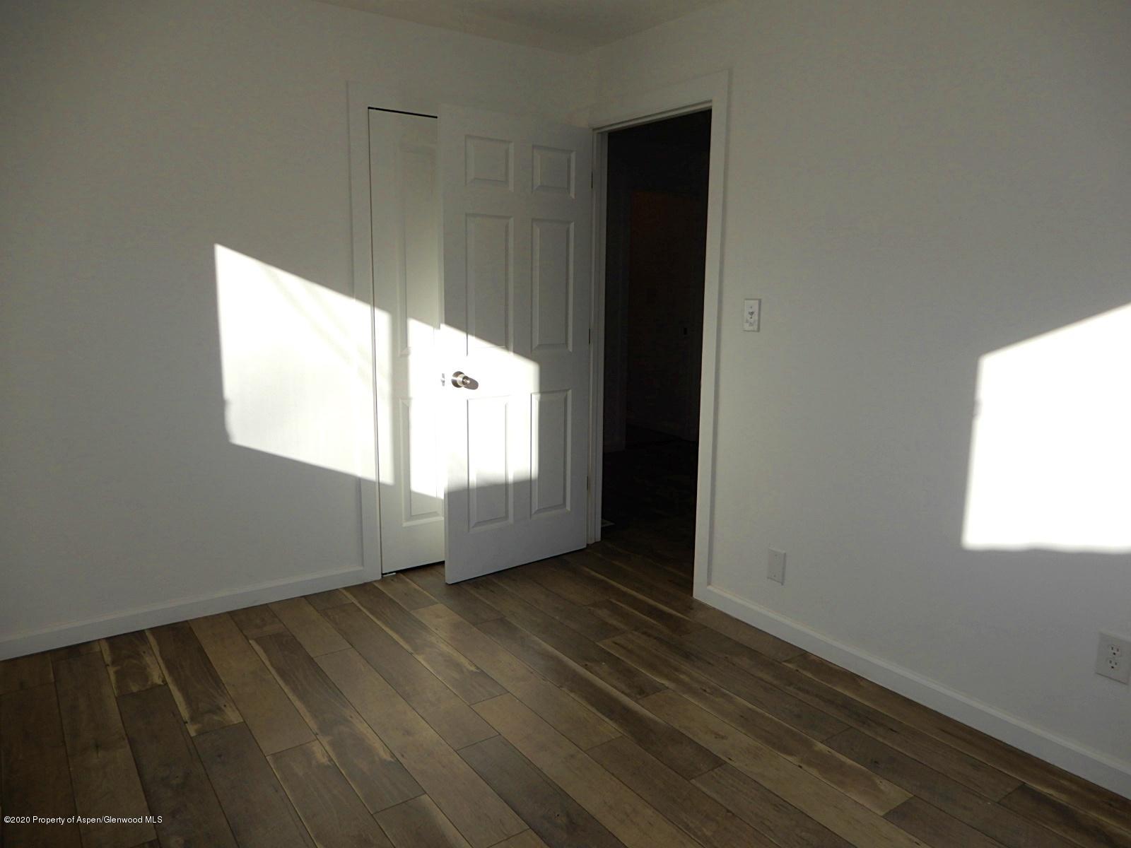119 June Avenue Rifle, CO 81650 - Photo 15 of 24 an empty room with wooden floor and windows