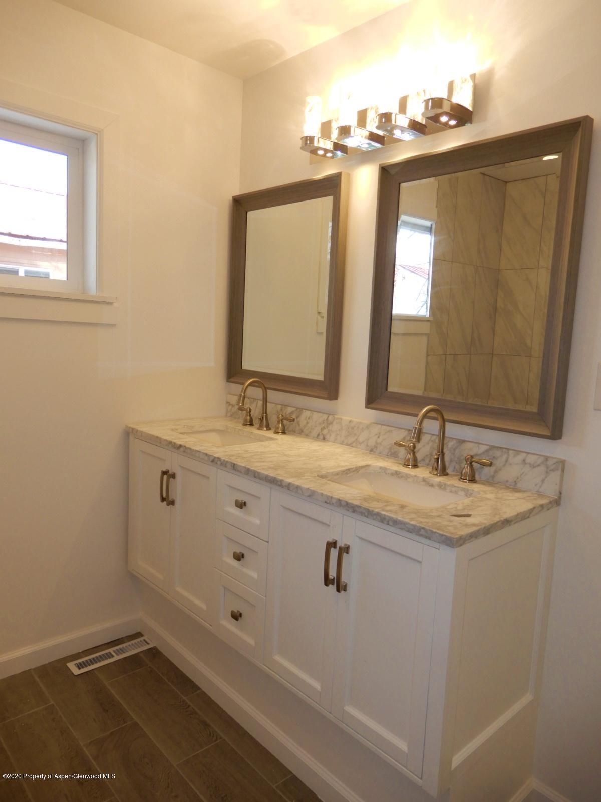 119 June Avenue Rifle, CO 81650 - Photo 21 of 24 a bathroom with a double vanity sink and mirror
