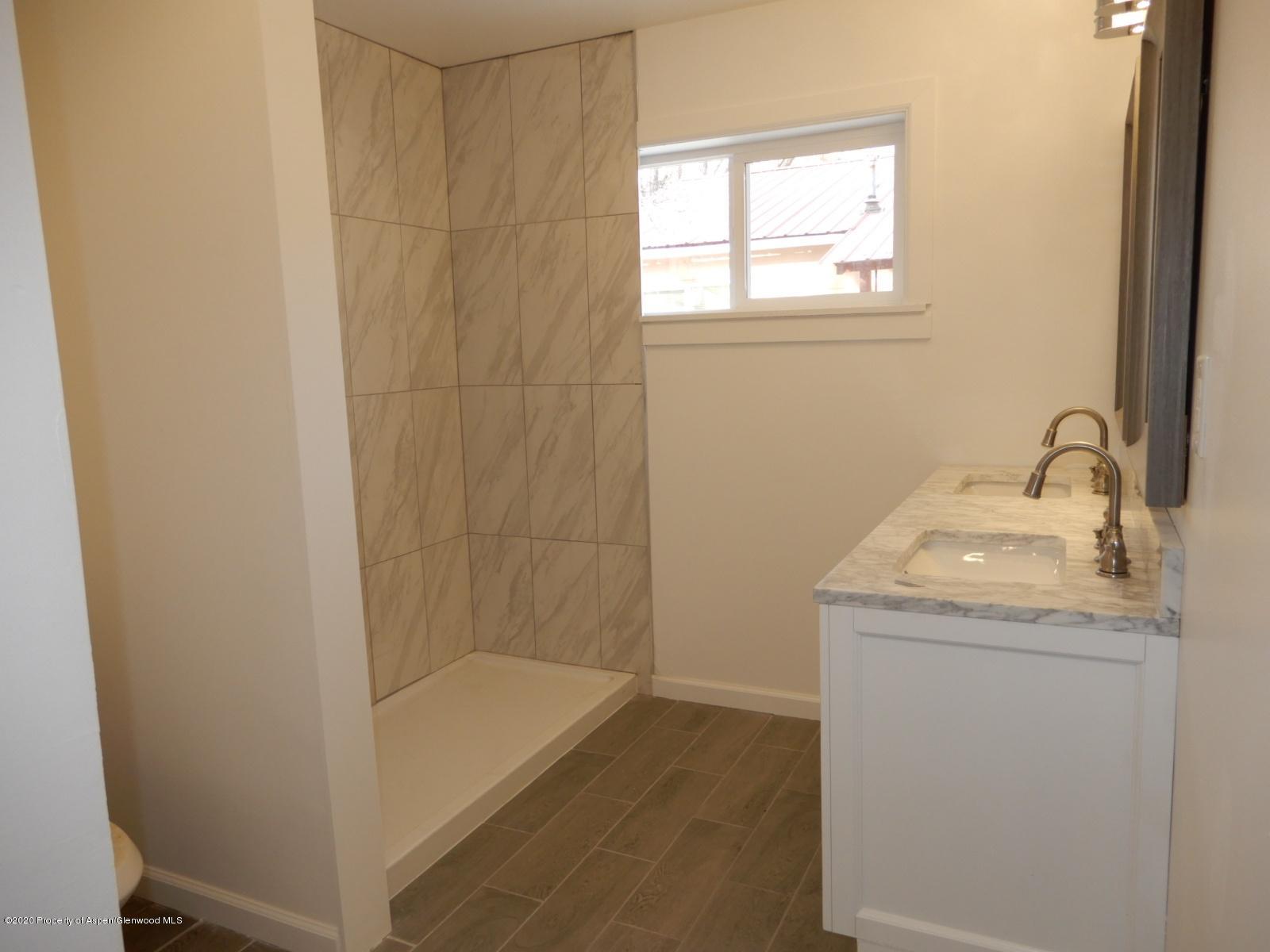 119 June Avenue Rifle, CO 81650 - Photo 22 of 24 a bathroom with a granite countertop sink a toilet and shower