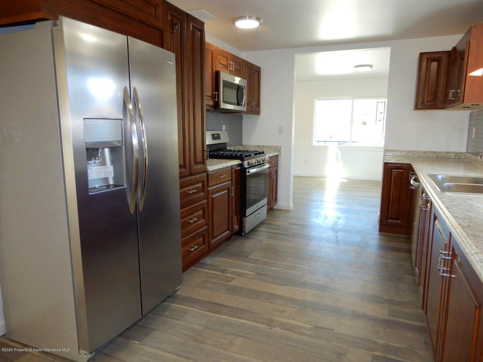 119 June Avenue Rifle, CO 81650 - Photo 5 of 24 a kitchen with stainless steel appliances granite countertop a refrigerator and a stove