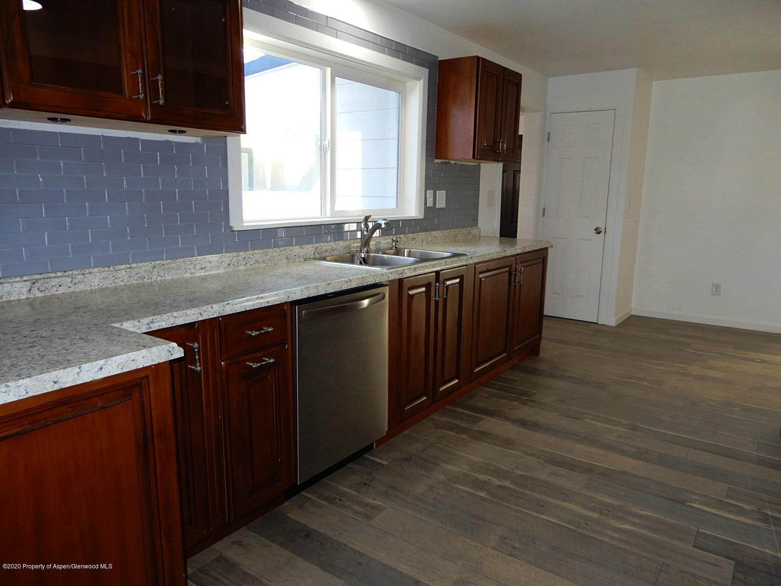 119 June Avenue Rifle, CO 81650 - Photo 6 of 24 a kitchen with stainless steel appliances granite countertop a sink counter space and wooden floor