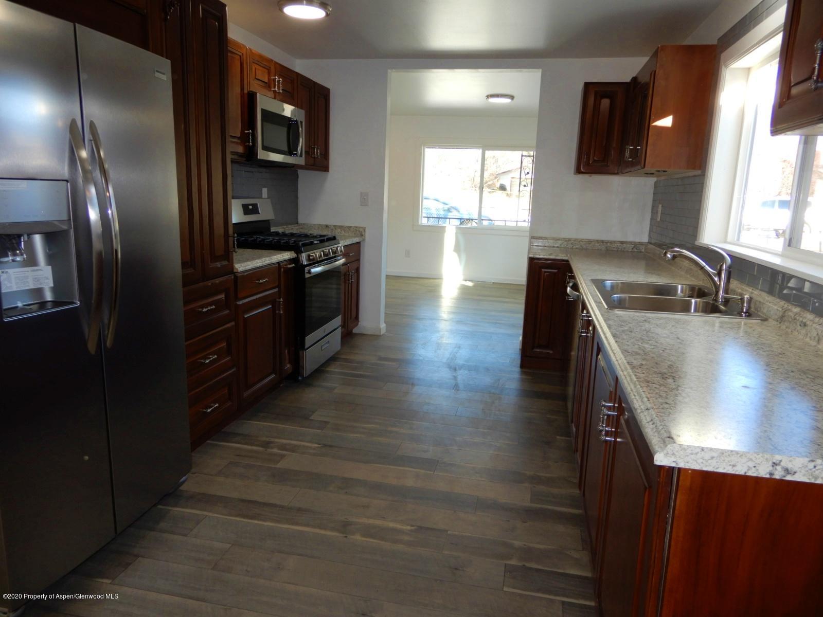 119 June Avenue Rifle, CO 81650 - Photo 7 of 24 a kitchen with stainless steel appliances granite countertop a sink a stove and a refrigerator