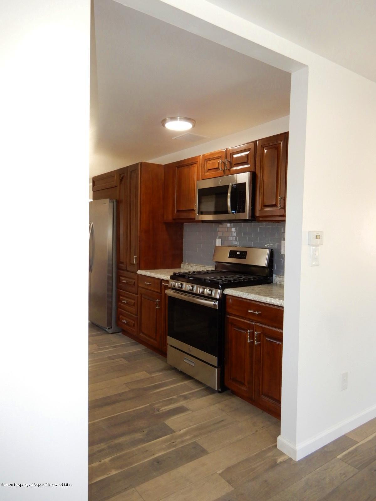 119 June Avenue Rifle, CO 81650 - Photo 8 of 24 a kitchen with stainless steel appliances a stove and a microwave