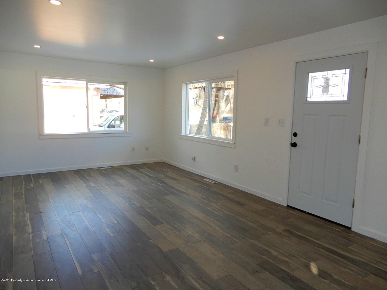 119 June Avenue Rifle, CO 81650 - Photo 10 of 24 an empty room with wooden floor and windows