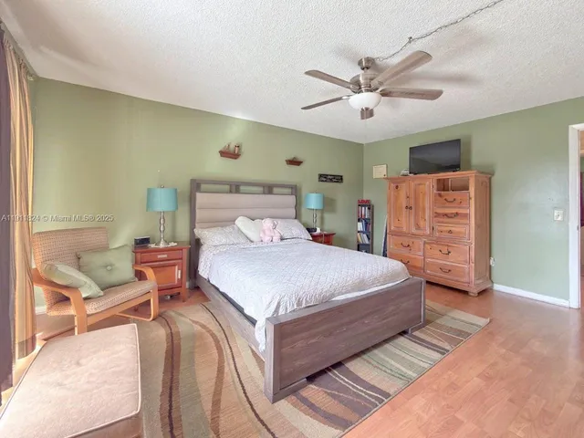 a bedroom with a bed and a ceiling fan