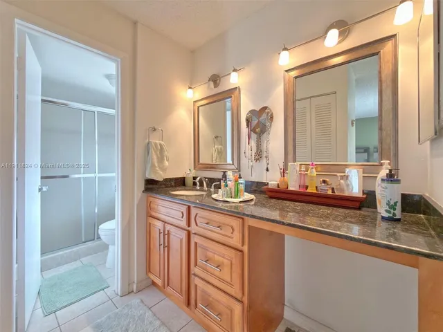 a bathroom with a granite countertop sink mirror and double
