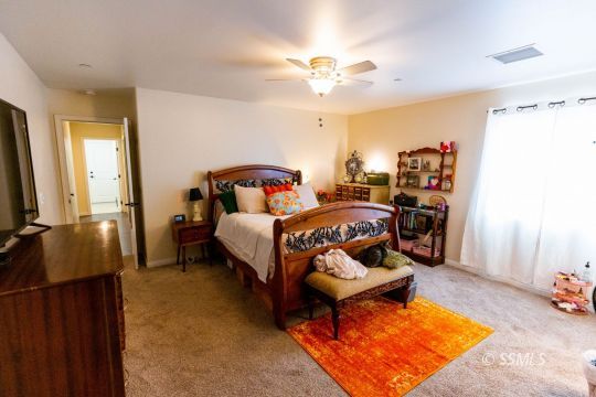 913 South McCall Street Ridgecrest, CA 93555 - Photo 18 of 40 a bedroom with a bed and a chandelier