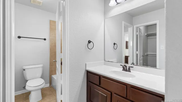 a bathroom with a sink a toilet and a large mirror