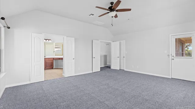 a view of a big room with chandelier fan and windows