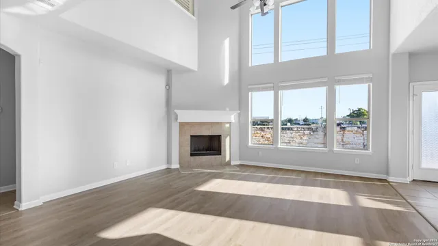 a view of an empty room with a window and fire place