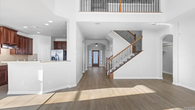 a view of entryway and kitchen with wooden floor