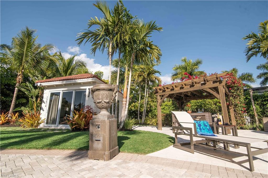 13614 Snapper Lane Naples, FL 34114 - Photo 15 of 19 a view of a patio with table and chairs potted plants and palm trees