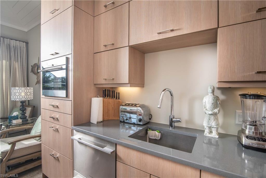 13614 Snapper Lane Naples, FL 34114 - Photo 5 of 19 a kitchen with stainless steel appliances granite countertop a sink dishwasher a refrigerator white cabinets and wooden floor