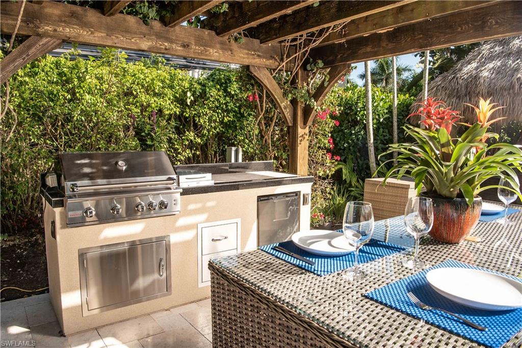 13614 Snapper Lane Naples, FL 34114 - Photo 10 of 19 a view of a patio with table and chairs potted plants with wooden floor