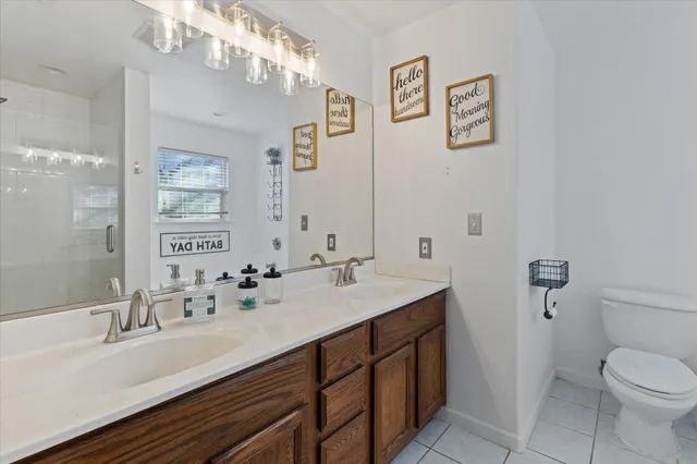 a bathroom with a sink a toilet and a large mirror
