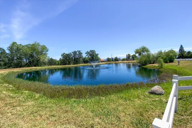 front view of a house with a garden and a car parked