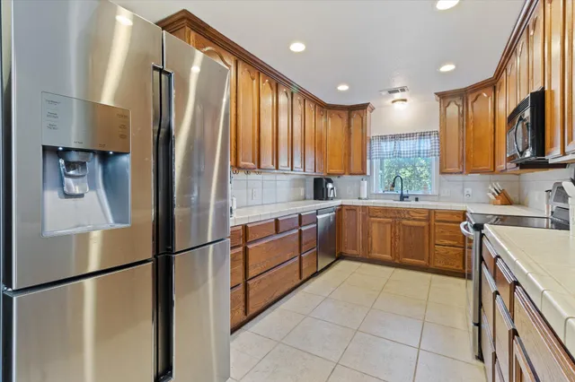 a kitchen with a sink refrigerator and cabinets