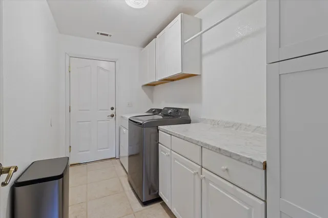 a utility room with cabinets washer and dryer