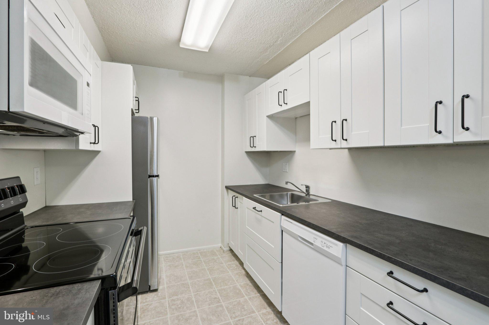 1420 Locust Street, Unit 7O Philadelphia, PA 19102 - Photo 10 of 53 a kitchen with stainless steel appliances granite countertop a sink stove and refrigerator