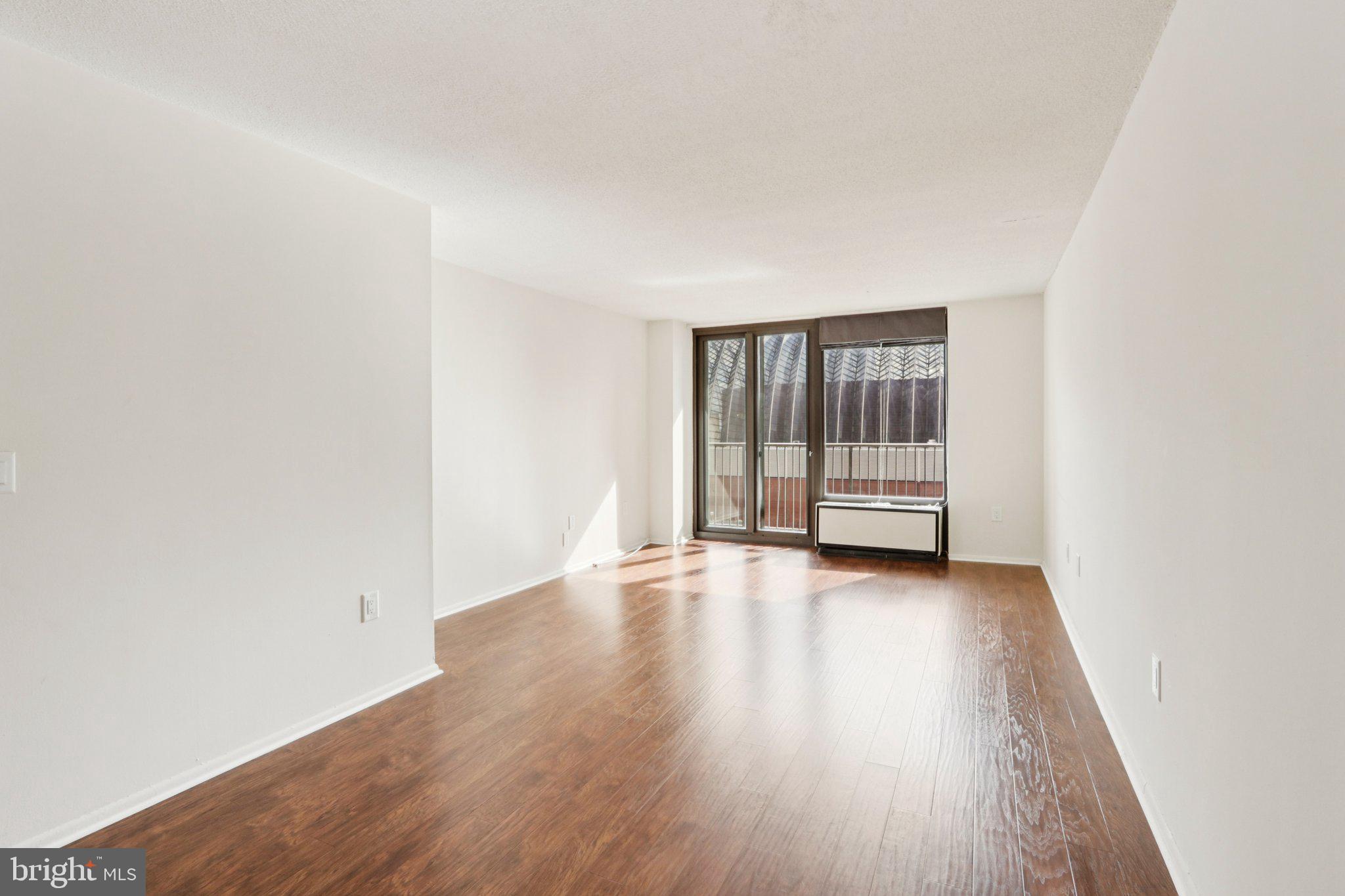 1420 Locust Street, Unit 7O Philadelphia, PA 19102 - Photo 16 of 53 an empty room with wooden floor and window