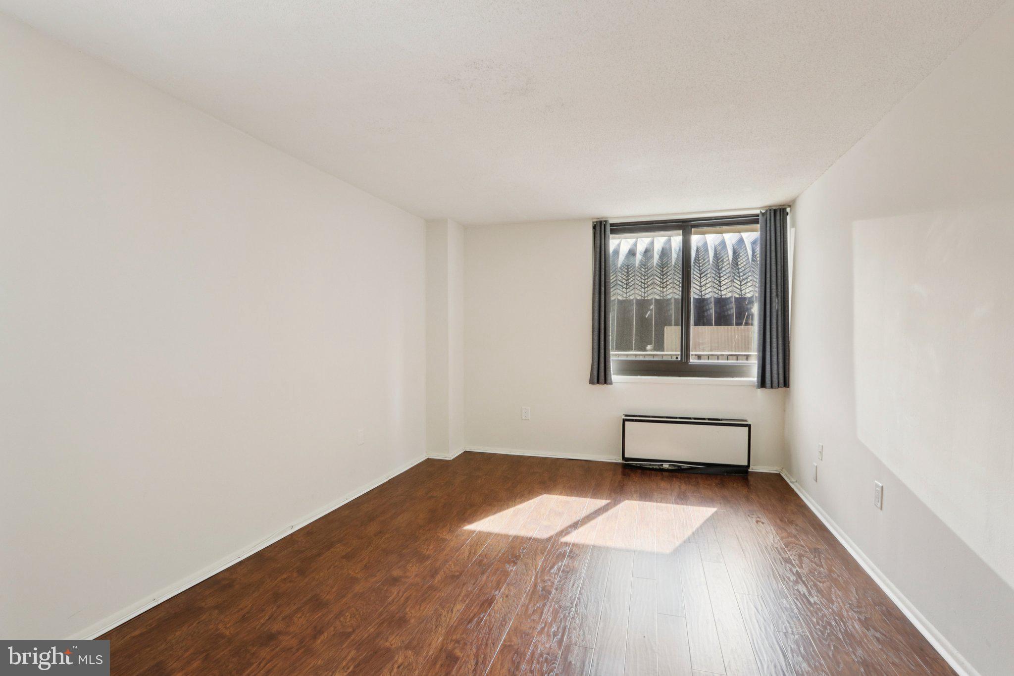 1420 Locust Street, Unit 7O Philadelphia, PA 19102 - Photo 21 of 53 a view of empty room with wooden floor and fan