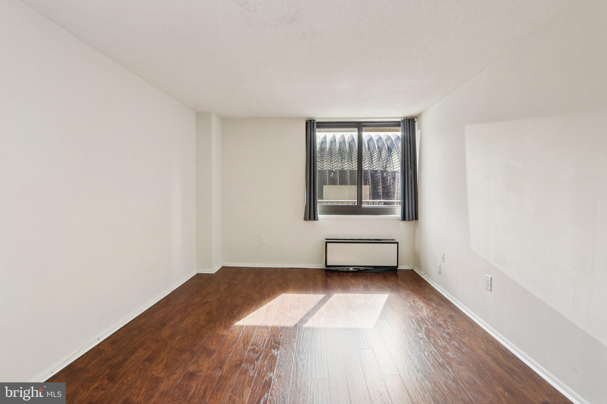 1420 Locust Street, Unit 7O Philadelphia, PA 19102 - Photo 25 of 53 an empty room with wooden floor and windows