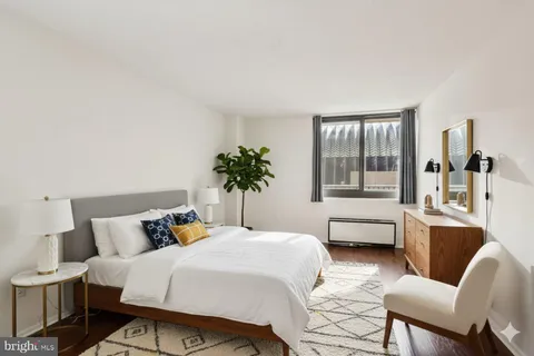 a bedroom with a large bed and windows