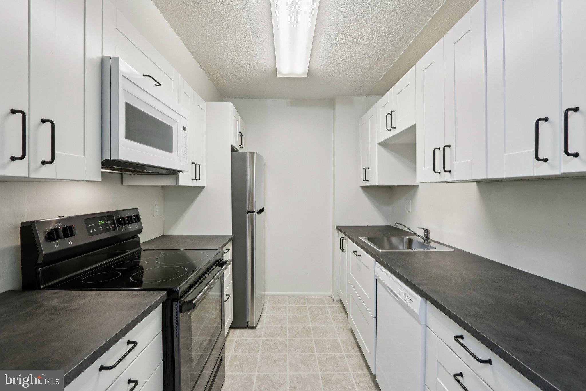 1420 Locust Street, Unit 7O Philadelphia, PA 19102 - Photo 8 of 53 a kitchen with stainless steel appliances granite countertop a sink stove and refrigerator