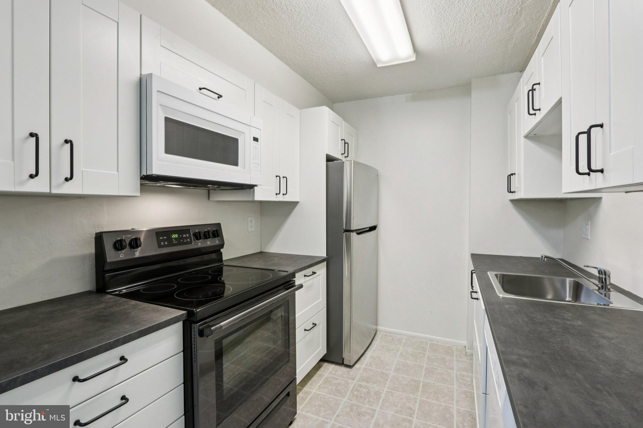 1420 Locust Street, Unit 7O Philadelphia, PA 19102 - Photo 9 of 53 a kitchen with stainless steel appliances granite countertop a sink stove and refrigerator